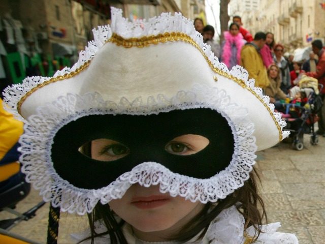 Avital Politi, 4, dressed as a princess from Venice, looks out from her mask during the Je