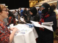 <> on January 25, 2017 in Berlin, Germany. BERLIN, GERMANY - JANUARY 25: Two women from Jordan (C) and Syria learn about job opportunities at a stand at the second annual jobs fair for refugees and migrants at the Estrel hotel and conference venue on January 25, 2017 in Berlin, Germany. The intiative brings together exhibitors from retail, …