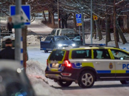 A shot-up car stands behind police cordons, where two men were found with gunshot wounds in Kista, Northwestern Stockholm, on late March 8, 2017. Both men were later pronounced dead at the hospital. / AFP PHOTO / TT News Agency / Jessica GOW / Sweden OUT (Photo credit should read …