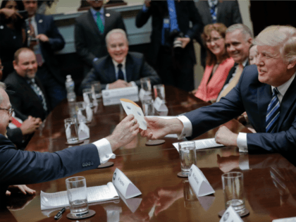 President Donald Trump takes card from Greg Knox's, left, written by his son, during