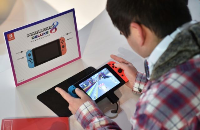 A visitor plays a Nintendo's new Switch game console during its game experience session in