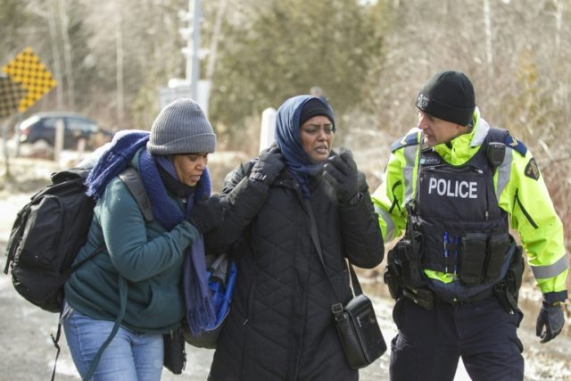 An RCMP officer speaks with women from Sudan after they illegally crossed the Canada-US bo