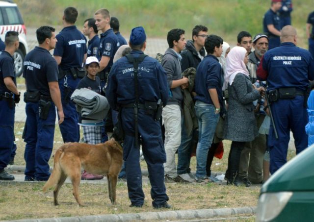 Asylum-seekers wait to board a bus at their temporary Hungarian home of Roszke on the Hung
