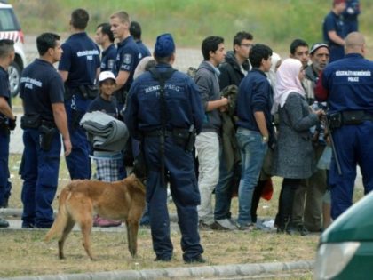 Asylum-seekers wait to board a bus at their temporary Hungarian home of Roszke on the Hung