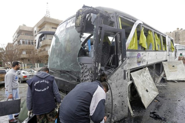 Syrian forensics experts examine a damaged bus following bomb attacks in Damascus' Old Cit