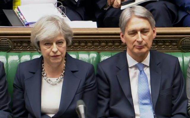 British Chancellor of the Exchequer Philip Hammond (R) and Prime Minister Theresa May (listen to a speaker during Prime Minister's Questions (PMQs) in the House of Commons in London on March 15, 2017