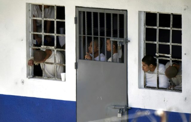 Inmates at a Guatemalan juvenile detention center peer out windows a day after a riot left