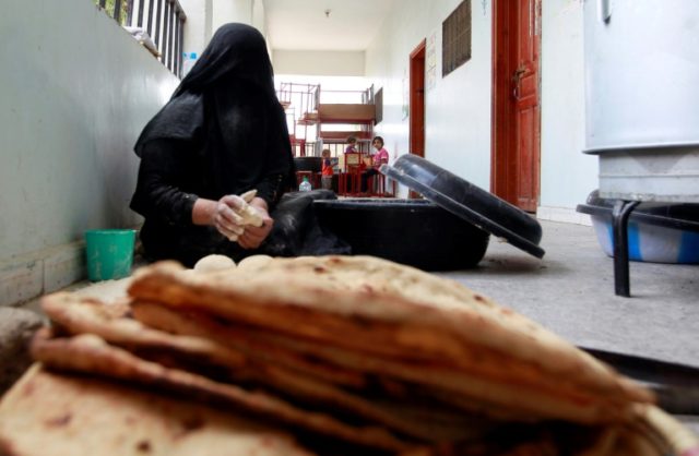 A displaced Yemeni woman makes bread at a school turned into a shelter in 2015 in the capi