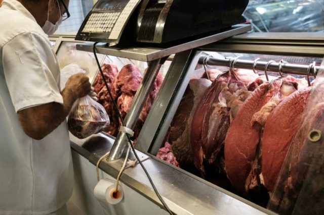 An employee sells meat during an inspection by Rio de Janeiro state's consumer protection