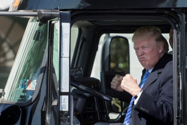 US President Donald Trump sits in the drivers seat of a semi-truck as he welcomes truckers