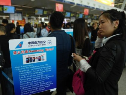 Passengers line up beside a safety warning about the Samsung Galaxy Note 7 smartphone at China's Wuhan airport in this October 2016 file picture