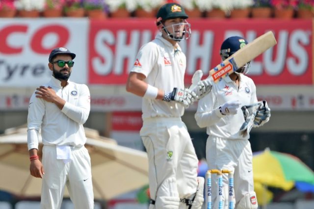 India captain Virat Kohli (L) looks on as Australia batsman Matthew Renshaw bats during th