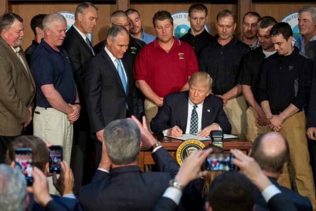 Surrounded by miners from Rosebud Mining, US President Donald Trump (C) signs he Energy In