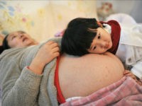 women-pregnancy-abortion-china-reuters Li Yan (L), pregnant with her second child, lies on a bed as her daughter places her head on her mother's stomach in Hefei, Anhui province February 20, 2014. REUTERS/China Daily