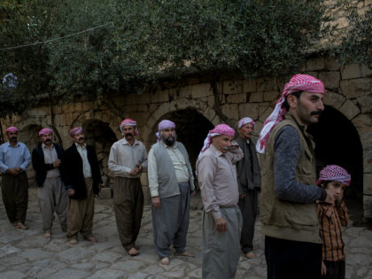 LALISH, IRAQ - NOVEMBER 11: Yazidi men line up before starting a religious ritual outside the holiest temple of the Yazidi faith while attending friday rituals on November 11, 2016 in Lalish, Iraq. Lalish is the site of the tomb of Sheikh Adi ibn Musafir, the central figure of the …