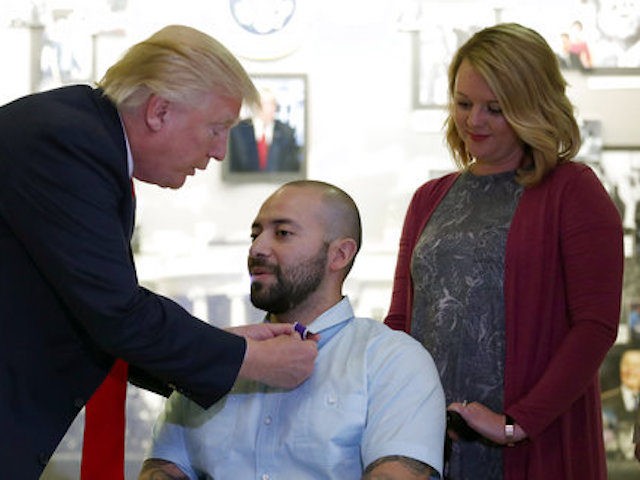 President Donald Trump awards a Purple Heart to U.S. Army Sgt. First Class Alvaro Barrientos, with his wife Tammy Barrientos nearby, at Walter Reed National Military Medical Center, Saturday, April 22, 2017, in Bethesda, Md. (AP Photo/Alex Brandon)