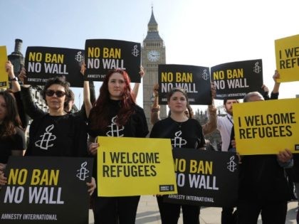 Amnesty International activists hold placards as they protest against US President Donald Trump's Travel ban, in Parliament Square on March 16, 2017 in London, England.