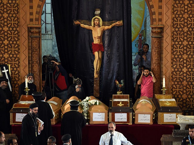 Coptic priests stand near the coffins of victims of the blast at the Coptic Christian Sain