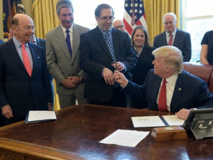 President Donald Trump hands United Steel Workers International President Leo W. Gerard the pen he used to sign an executive memorandum on investigation of steel imports, Thursday, April 20, 2017, in the Oval Office of the White House in Washington. Commerce Secretary Wilbur Ross is second from left. (AP Photo/Susan …