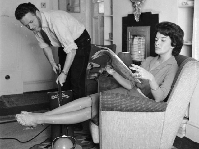 September 1958: An employee of the 'Housewives Help Service' hoovering the livi