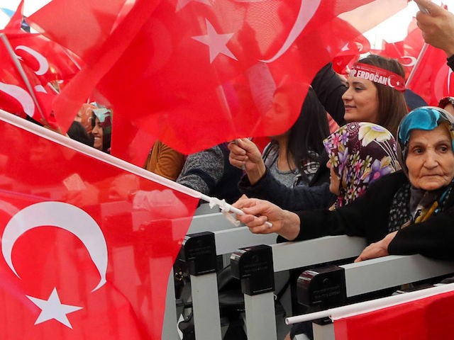 Supporters of the "yes" wave Turkish National flags as they cheer Turkish presid