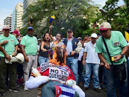 Demonstrators burn an effigy of President Nicolas Maduro during a protest at the east side