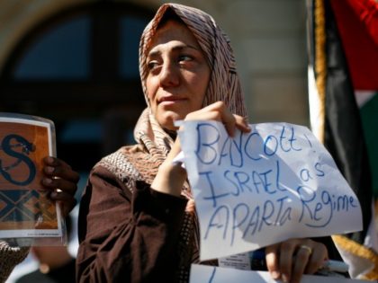 A Palestinian woman hold up a placard reading ' boycott Israel as Aparta regime'