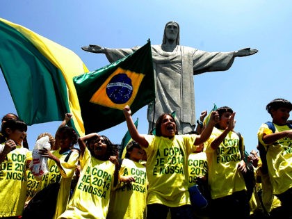 Brazilian schoolboys wave flags and cheer in front of the statue to Christ the Redeemer 30