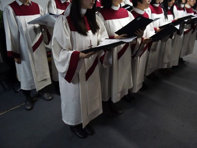 This photo taken on December 24, 2014 shows the choir of an underground church singing at a Christmas Eve service at an apartment in Beijing. China is now home to an estimated 70 million Christians, according to a 2011 survey by the Pew Research Center, as people search for a …