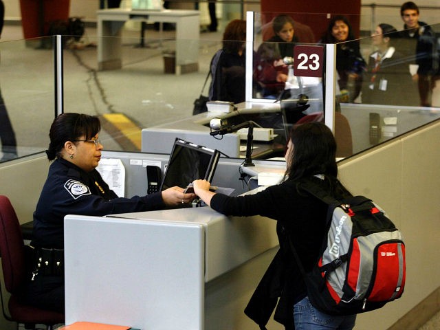 A foreign airline passenger is greeted by a Customs and Border Protection Officer at Harts