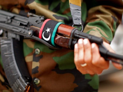 With a Libyan flag on his automatic weapon, a soldier stands guard outside a meeting between U.S. Secretary of State Hillary Rodham Clinton and Libya's Transitional National Council President Mustafa Abdel-Jalil at the World Islamic Call Society Headquarters, during her visit to Tripoli in Libya Tuesday, Oct.18, 2011. (AP Photo …