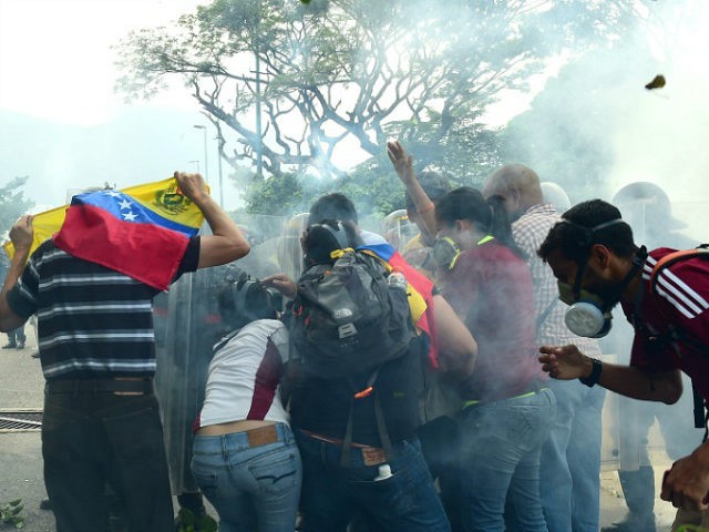 Opposition activists clash with riot police during a protest march in Caracas on April 26,