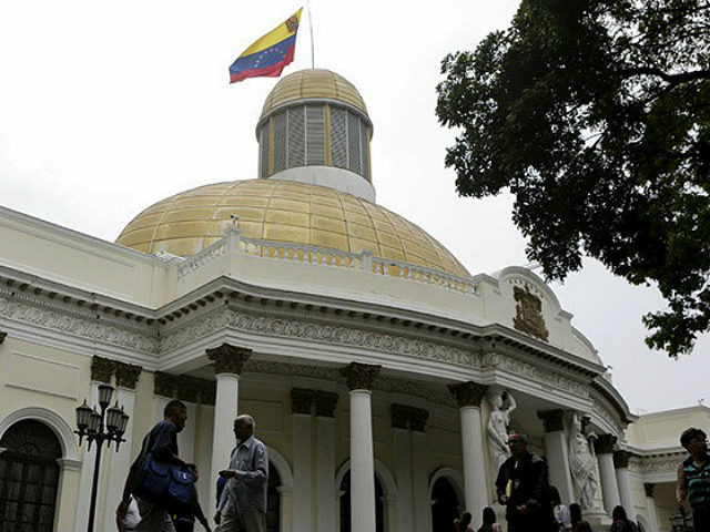 People walk past the National Assembly building during a parliamentary session in Caracas,