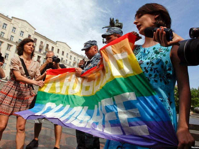 Russian police take away a banner from gay rights activists during a rally outside the may