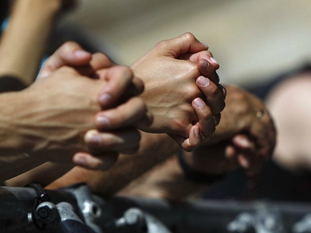 People pray during a religious service for bikers at the German Evangelical Church Congres