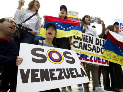 Demonstrators who are against the Venezuelan government chant outside of the Organization of American States (OAS) during the special meeting of the Permanent Council, in Washington, Monday, April 3, 2017, to consider the recent events in Venezuela. (AP Photo/Jose Luis Magana)