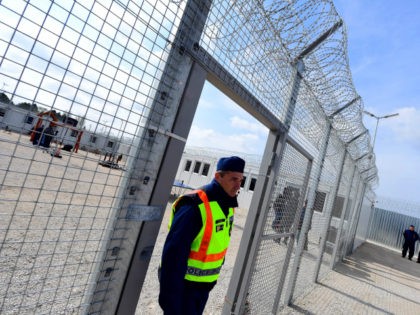 A police officer walks through a gate in at the Tompa border station transit zone on April 6, 2017 as the Hungarian Interior Minister Sandor Pinter (not pictured) presents the camp to the media. The migrant transit complex on the Hungarian side of the border has been expanded to become …