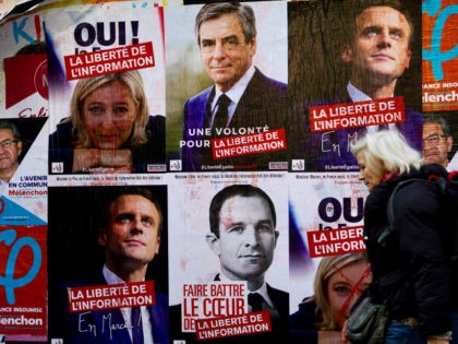 A woman walks past electoral posters of French presidential election candidate for the far-left coalition La France insoumise Jean-Luc Melenchon, French presidential election candidate for the far-right Front National (FN) party Marine Le Pen, French presidential election candidate for the right-wing Les Republicains (LR) party Francois Fillon, French presidential election …