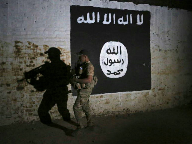 FILE - In this March 1, 2017 file photo, an Iraqi soldier inspects a recently-discovered train tunnel, adorned with an Islamic State group flag, that belonged to the former Baghdad to Mosul line, that was turned it to a training camp for IS fighters, in western Mosul, Iraq. Some 40 …
