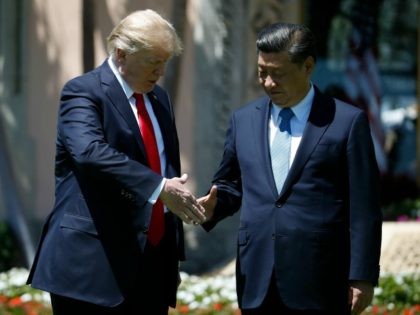 President Donald Trump and Chinese President Xi Jinping reach to shake hands at Mar-a-Lago