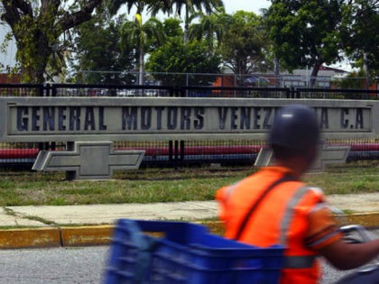 A motorcyclist rides past the General Motors' plant in Valencia, Venezuela, Thursday, Apri