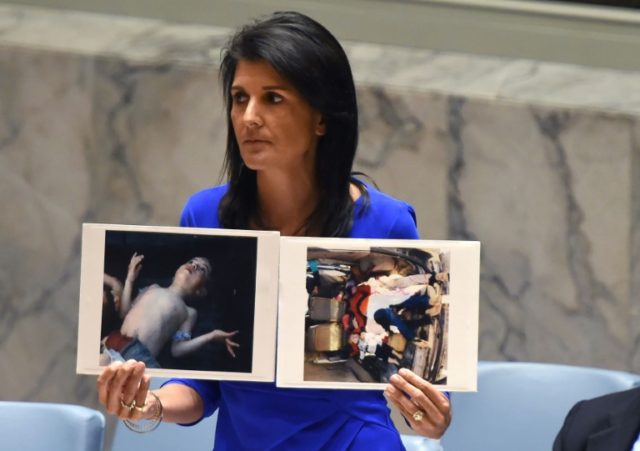 US Ambassador to the UN Nikki Haley holds photos of victims as she speaks as the UN Securi