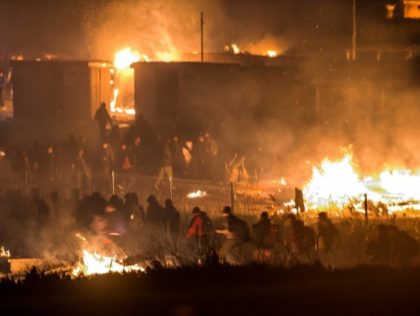 Migrants flee as a huge fire destroys the Grande-Synthe camp outside the northern French city of Dunkirk