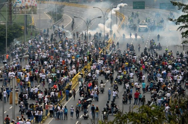 Demonstrators clash with the riot police during a protest against Venezuelan President Nic