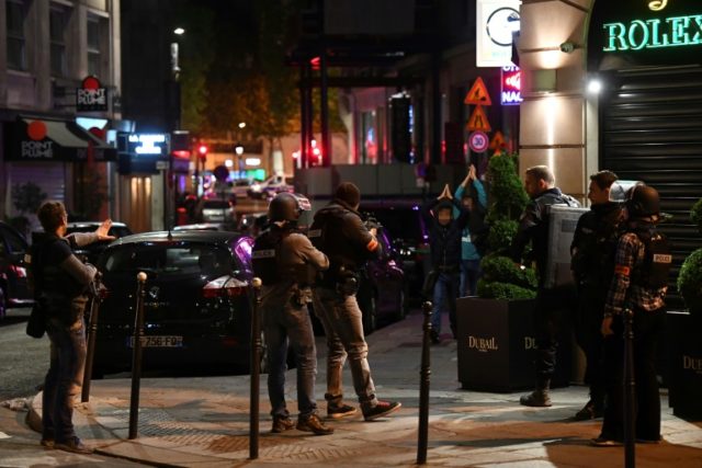 Police check passersby near the Champs Elysees in Paris after a shooting which left one of