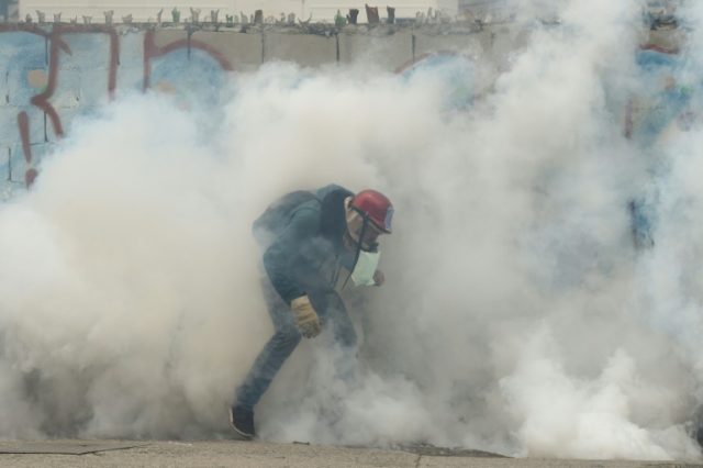 A demonstrator clashes with the riot police during a protest against Venezuelan President