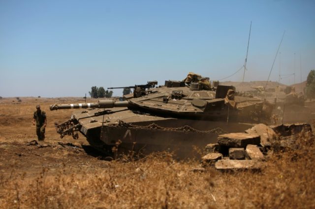 An Israeli soldier directs a Merkava tank stationed in the Israeli-annexed Golan Heights n