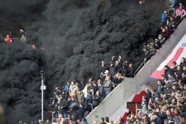 Thick black smoke forces a five-minute interruption of play during the crunch PSV Eindhove