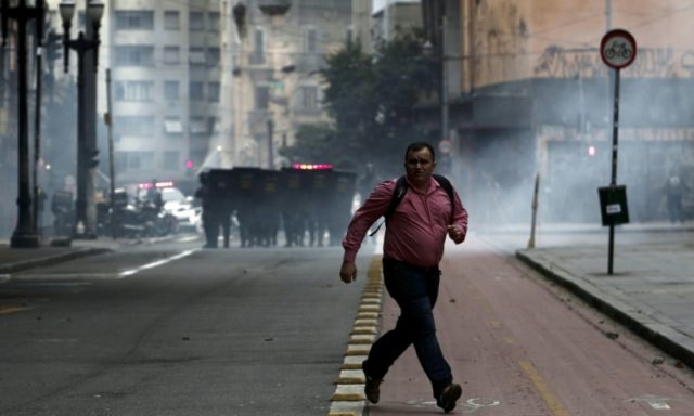 Riot police fire tear gas at demonstrators during a general strike against the Brazilian s
