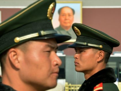 Chinese paramilitary police stand guard in front of the portrait of late leader Mao Zedong at Tiananmen Square in Beijing on November 6, 2012